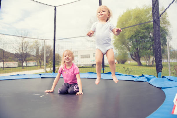 istock Two beautiful kids jumping on the trampoline and enjoying. 1133667774