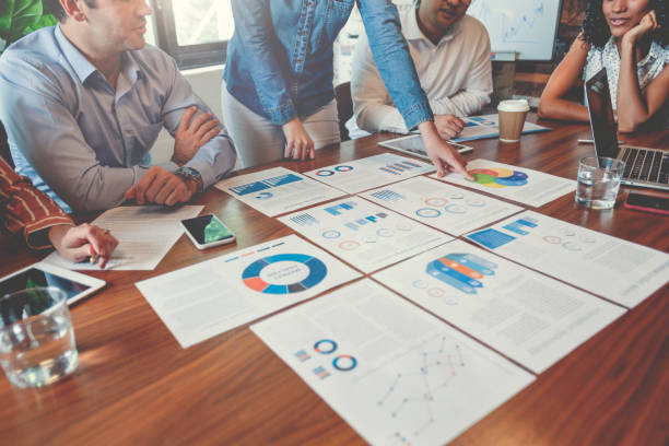 istock Paperwork and hands on a board room table at a business presentation or seminar. 1133668038