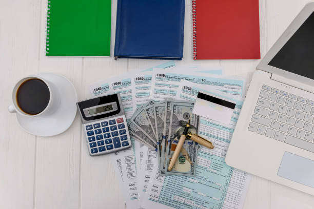 istock 1040 form with dollars, calculator and laptop 1133670005