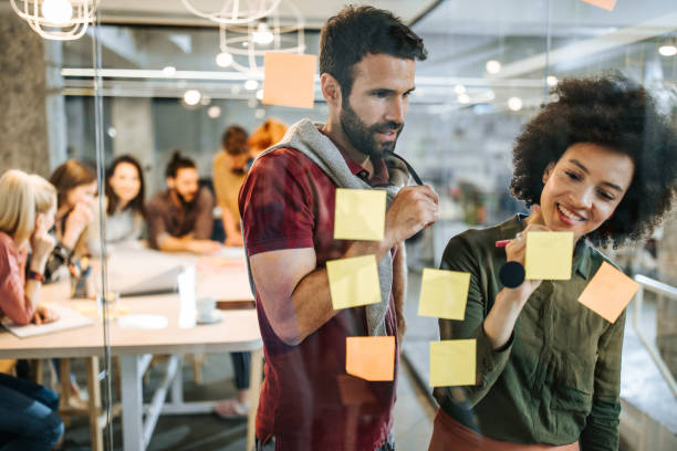 istock Young creative people making plans on a glass wall at casual office. 1133672221