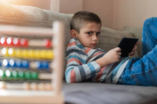 Photo of Schoolboy with a tablet at home