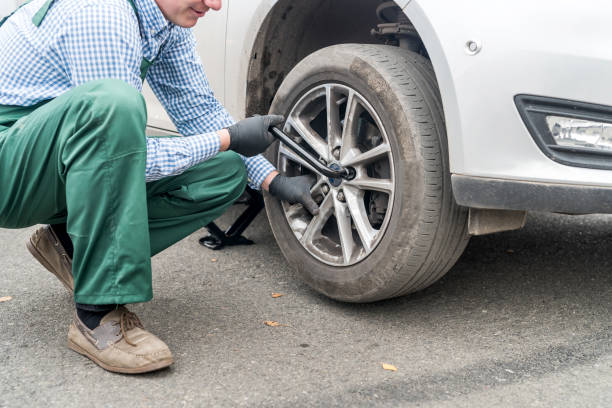 istock Man fixing wheel in car on roadside 1133672919