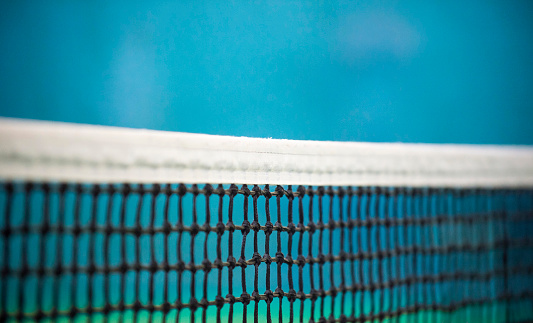 Net of tennis court on blue wall background