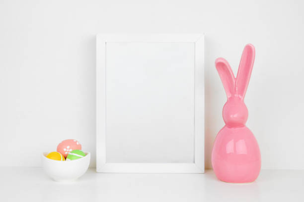 istock Mock up white frame with Easter Eggs and modern pink bunny decor on a shelf 1133673746