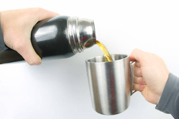 istock tea is poured into a mug of thermos 1133674037