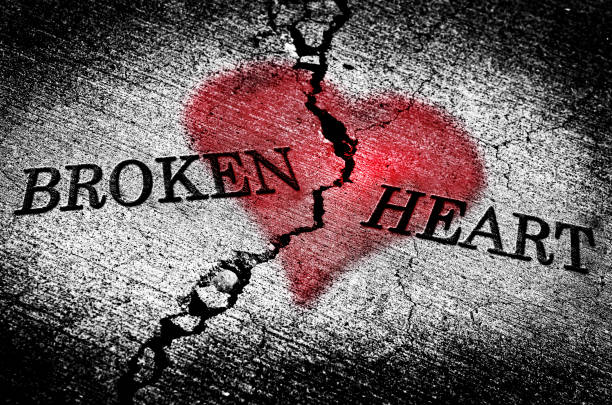 Large crack in cement with words broken heart and red texture emotions hurt feelings