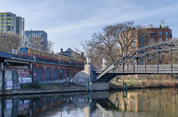 River Spree bridged by the Berlin Stadtbahn with a moving train and the bridge Gerickesteg Berlin, Germany - February 17, 2019: Embankment Bellevue Ufer and the River Spree bridged by the Berlin Stadtbahn with a moving train and the pedestrian steel bridge Gerickesteg with its Art Nouveau Gas lightings moabit stock pictures, royalty-free photos & images