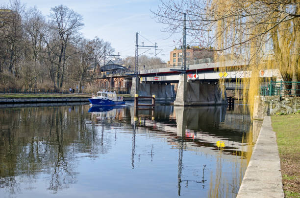 Banks of the river Spree with the steel railway bridge Bellevue and a police boat in Berlin, Germany Berlin, Germany - February 17, 2019: Embankment Bellevue Ufer of the River Spree with the steel box girder railway bridge Bellevue and a police boat. View from the embankment Helgolaender Ufer moabit stock pictures, royalty-free photos & images