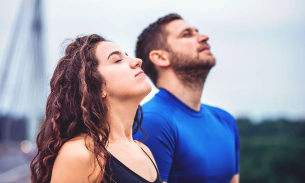 frische luft atmen. junges ehepaar genießt gemeinsam im morgendlichen training im freien. sport, fitness, erholungskonzept - sichtbarer atem stock-fotos und bilder