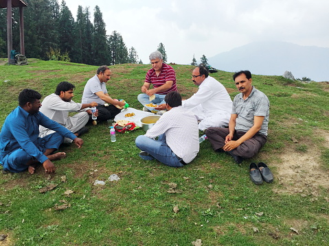 Tourists hikers resting and eating food on grass ground during hiking.
Location: Mushkpuri, Nathia Gali, Punjab, Pakistan.
Date Taken: June 18, 2017.