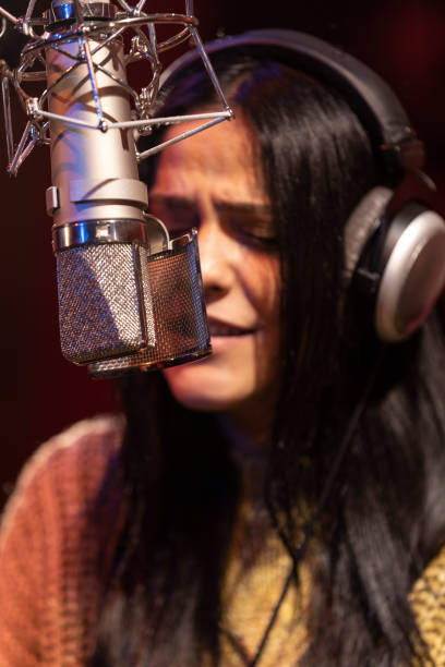 istock Famele singer performing for recording in sound studio 1133679045