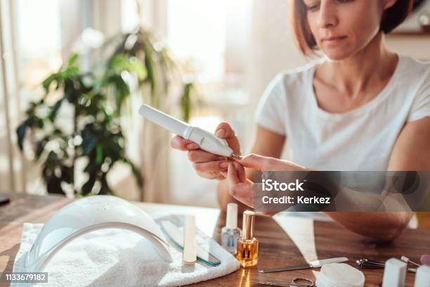 Woman Filings Nails With Electric Nail File Stock Photo - Download Image Now - Fingernail, Nail File, Electricity