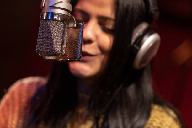 istock Famele singer performing for recording in sound studio 1133679874