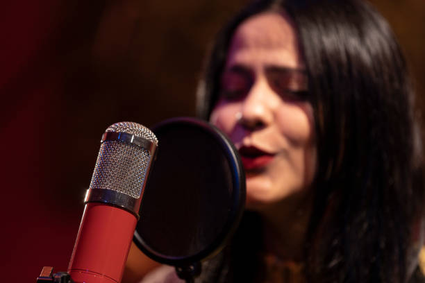 istock Famele singer performing for recording in sound studio 1133680909