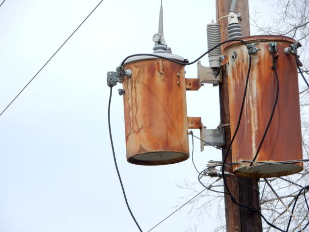 dois transformadores elétricos oxidados em um pólo de madeira - transformers - fotografias e filmes do acervo