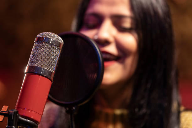 istock Famele singer performing for recording in sound studio 1133681377