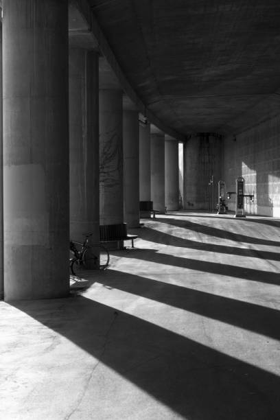 istock Black and white of light and shadows under a concrete structure supported by pillars 1133682270