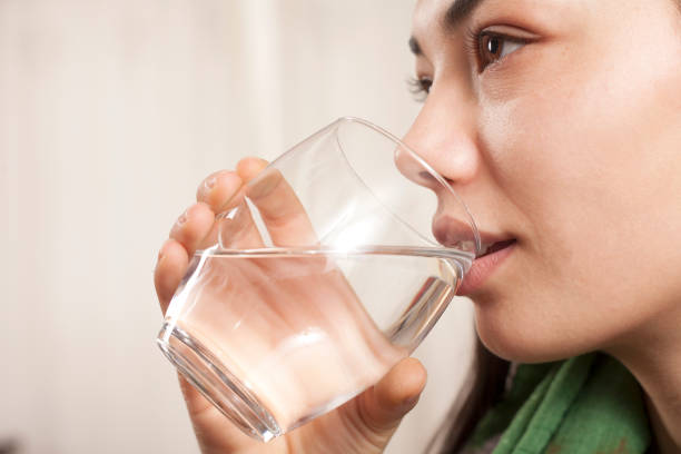 istock woman drinking water 1133683226