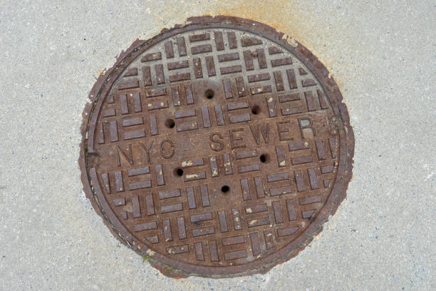 istock Old rusty sewer hatch on concrete surface, New York City. 1133684223