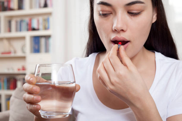 istock woman taking medicine tablet 1133685180