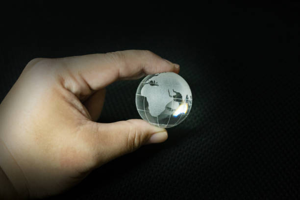 istock The glass ball planet earth and hand image. 1133701409
