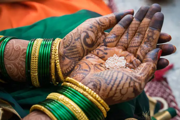 A woman is decorated with traditional henna mehendi designs during a Hindu wedding celebration