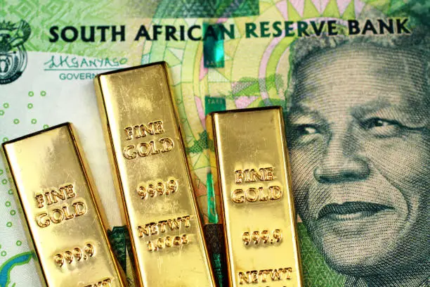 Photo of A South African ten rand bank note with three small gold bars