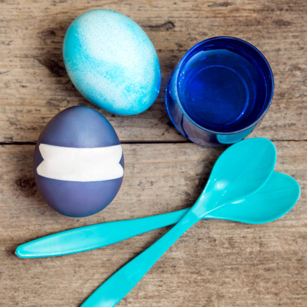 blue easter eggs, egg dyes and a spoon on wooden table, flatlay with copyspace - nodoby imagens e fotografias de stock