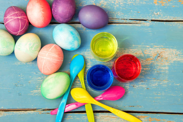 красочные пасхальные яйца, яичные красители и ложки на винтажном деревянном столе, flatlay - nodoby стоковые фото и изображения
