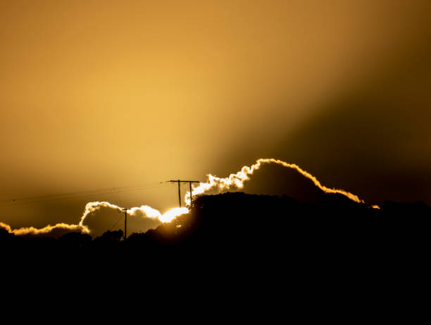 istock Electricity pole with sunrise and silver lined clouds 1133712724