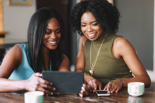 istock Young women at home, watching stuff on tablet together 1133712814