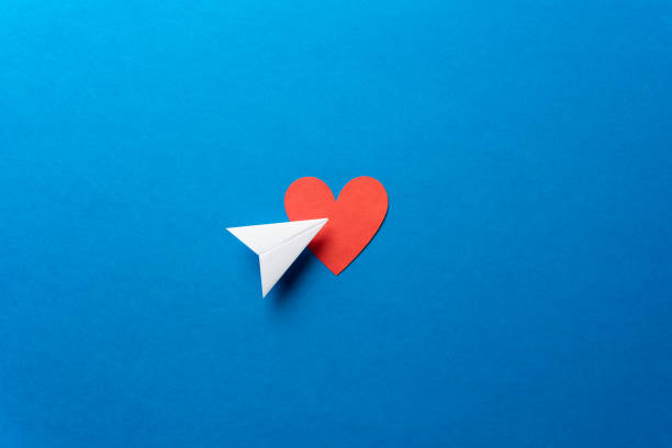istock Paper airplane with red heart shape on blue background. Sharing and send symbol concept. Airplane flight transport sign. Landing page concept. 1133713817