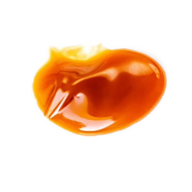 istock Caramel sauce isolated on white background. Flowing vanilla toffee sauce top view 1133716491