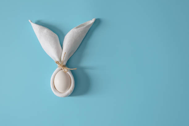 istock Easter table decoration with napkin in the form of rabbit ears and eggs. Festive Easter minimalism. 1133720755