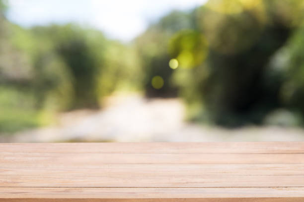 istock Wooden board empty table in front of blur Abstract natural green light 1133722200