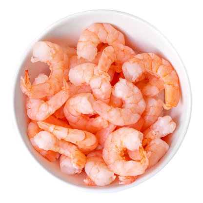 Peeled shrimps in a bowl isolated on white background. Top view