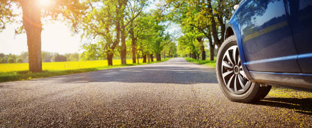 Car on asphalt road in summer Car on asphalt road on summer day at park panoramic country road single lane road sky stock pictures, royalty-free photos & images