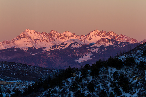 Snow Capped mountains seen from Mesa Verde NP after the sun set leaving a pink glow on the mountains and sky
