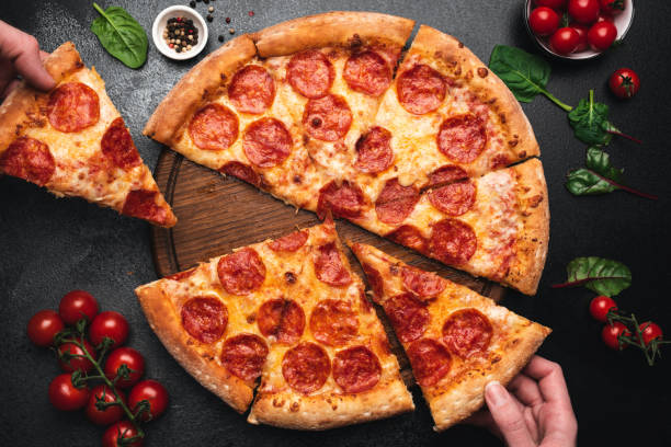 picking scheibe pfefferoni pizza - pepperonipizza stock-fotos und bilder