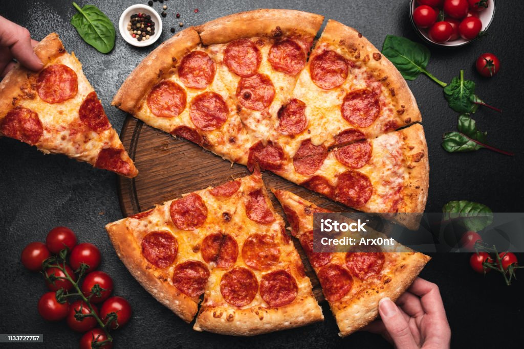 Plockning bit av pepperoni pizza - Royaltyfri Pizza Bildbanksbilder