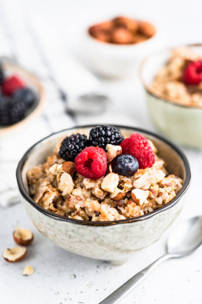 овсяная каша с ягодами, семенами и орехами - oatmeal heat bowl breakfast стоковые фото и изображения