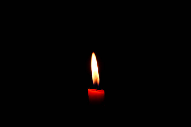 istock One light flame candle burning brightly on black background 1133729685