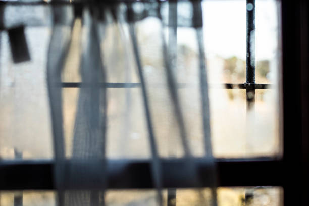 istock Water drops and curtains taking visibility on a window glass from indoor view 1133729861