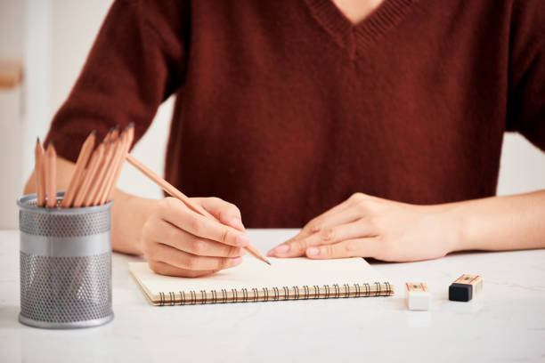 istock Hand with color pencils and blank sheet of paper on white table 1133732421