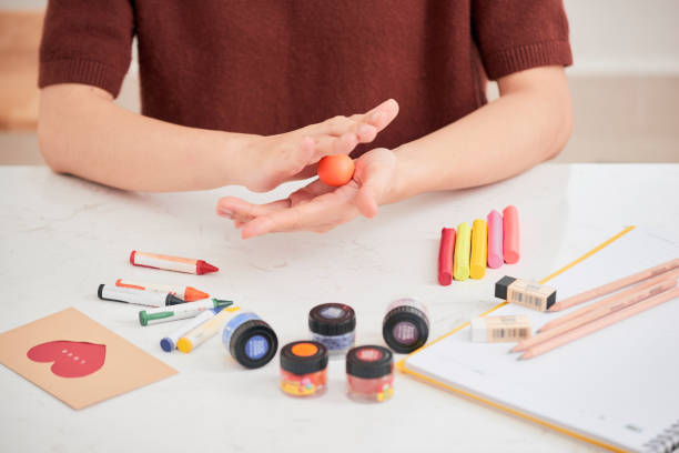 Female hands working with polymer clay. The process of working with the plastic on a white background. Female hands working with polymer clay. The process of working with the plastic on a white background. polymer clay stock pictures, royalty-free photos & images