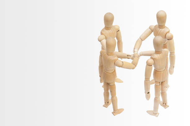 istock Business Unity and Teamwork Concept : Group of wooden figure mannequin putting stack their hands together. 1133736015