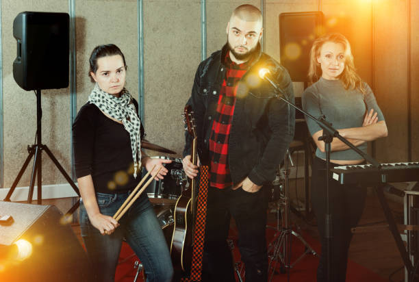istock expressive group of rock musicians posing with instruments 1133741184