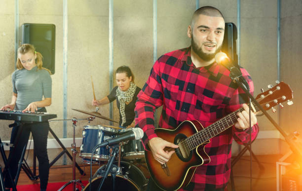 istock Guy guitar player and singer practicing with band members in re 1133741191