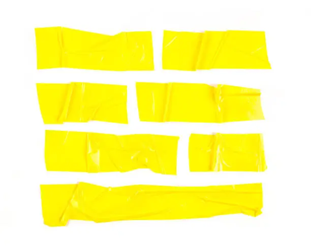 Photo of Set of yellow tapes on white background. Torn horizontal and different size yellow sticky tape, adhesive pieces. - Image