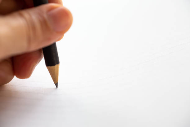 istock Hand writing letter on white paper background, A black pencil, Close up & Macro shot, Selective focus, Stationery concept 1133742890